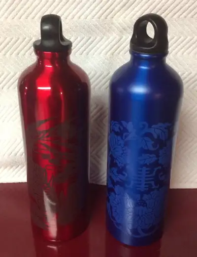 Gaiam water bottles for sale. One red with fish, one blue with floral pattern. Red has little paint...