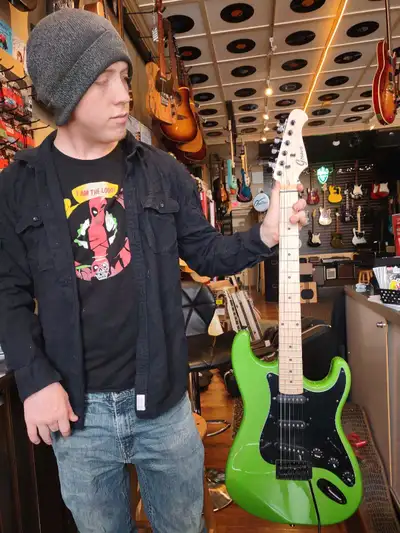 Get ready to rock with this Groove Green Machine electric guitar! This eye-catching instrument featu...