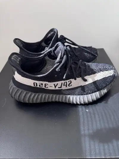 Selling a pair of used Adidas Yeezy Boost 350 sneakers, featuring a stylish black design with the si...