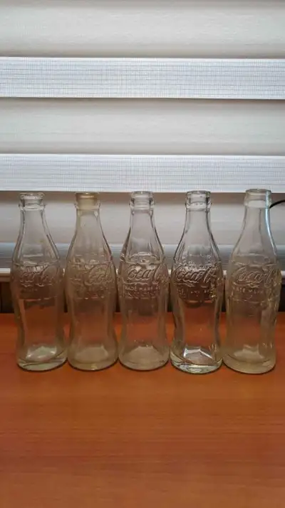 Empty Coca-Cola bottles. Clear. Green. Heavy. Coke. Cities., View more