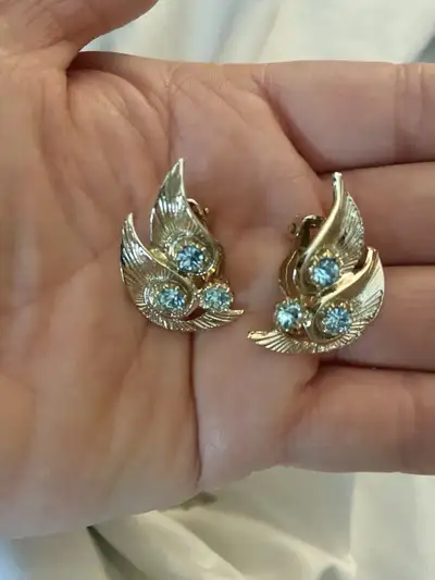 These are a pair of vintage gold tone clip on earrings with pale blue stones. They are in good condi...