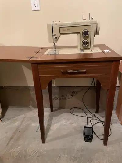 Older sewing machine in cabinet. Still works.