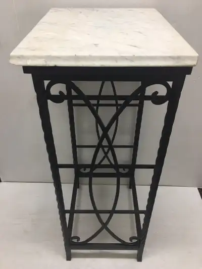Iron plant stand or garden table with marble top. Measures 38" H, 20" W, 15" D.