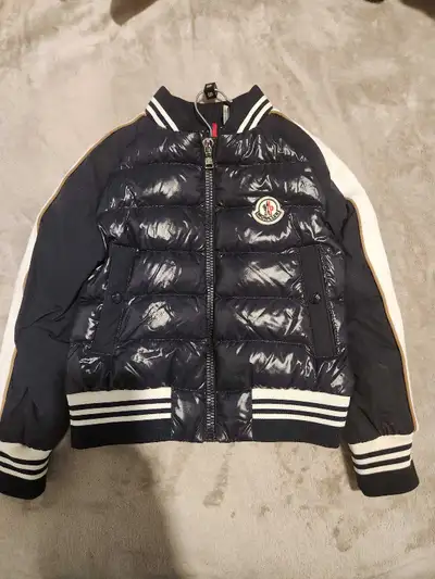 This is a stylish used Moncler jacket, perfect for keeping your little one warm and fashionable. It'...