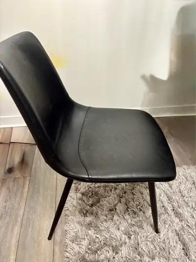 Stylish modern black chair with faux leather upholstery and sturdy metal legs. Comfortable and suppo...