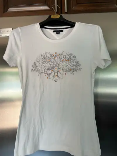 This is a Tommy Hilfiger white T-shirt, size medium, featuring a sparkly and stylish graphic design,...