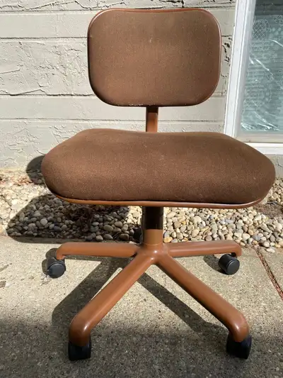 This is a brown office chair that has served its purpose well and is still functional, although it s...