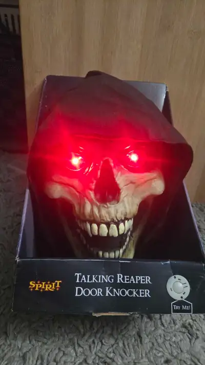 Add a spooky touch to your Halloween decor with this Spirit Talking Reaper Door Knocker, featuring r...