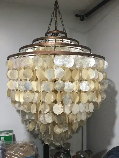 Strands of shells hang from this 4 tiered wired frame. Breezy casual style make this chandelier a be...
