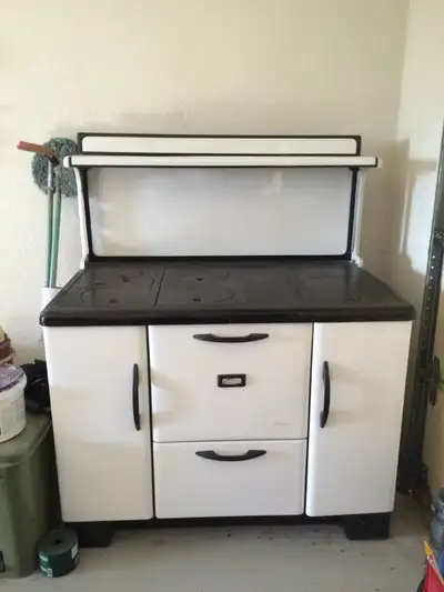 This used Antique Beach wood stove features a classic design with a durable cooktop and a spacious o...