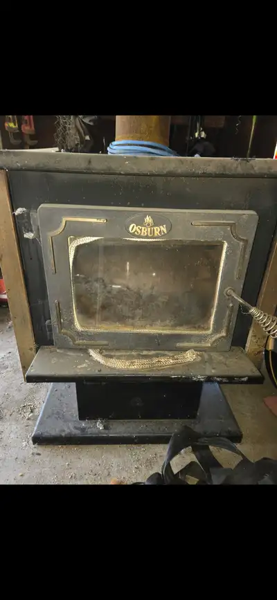 Osburn wood Burning stove, cast iron with electric fan and piping.