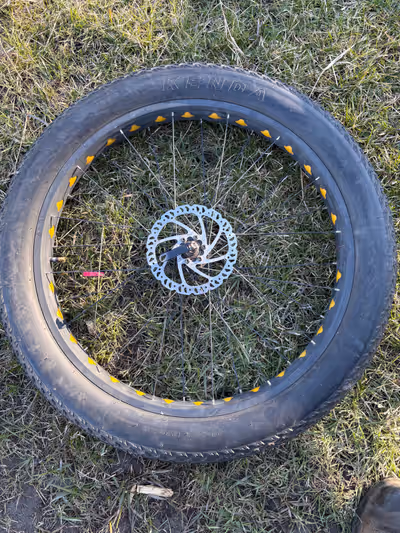 This is a used Kenda Juggernaut 26x4.0 fat tire mounted on a wheel with a disc brake. It's in good c...