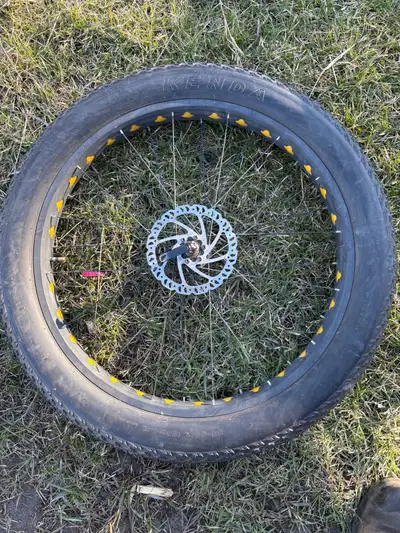 This is a used Kenda Juggernaut 26x4.0 fat tire mounted on a wheel with a disc brake. It's in good c...