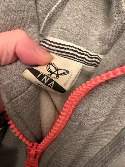 This is a like-new, small-sized Aritzia TNA sweater with a stylish grey colour and coral zipper. It'...