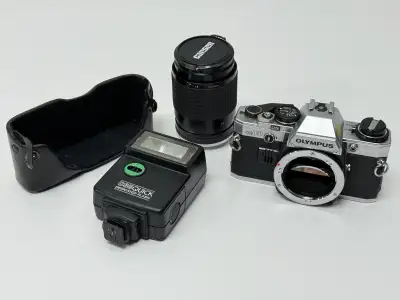 Classic Olympus OM-10 35mm film camera body paired with a vintage Kiron 135mm f/2.8 telephoto lens....
