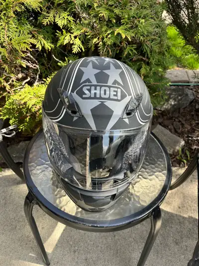 SHOEI helmet. Black with cool grey star and stripe graphics. Has clear visor. Foam padding on inside...