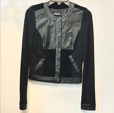 Tailored women's jacket with leather front panels. Collarless neckline and hidden front zip. Angled...