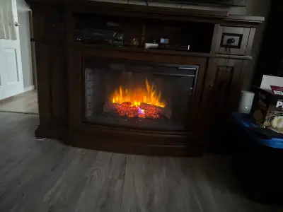 Electric fireplace, comes with remote, can be used with heat or just flame. Wood with metal insert....