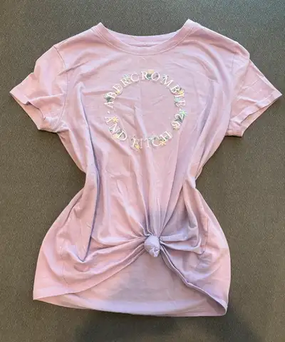 Check out this stylish Abercrombie Kids T-shirt, perfect for young fashion enthusiasts! This lilac t...