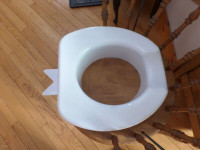 Raised toilet seat for a round bowl.