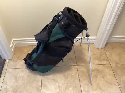 This is a stand bag for golf clubs with a black and green design, perfect for carrying your clubs on...