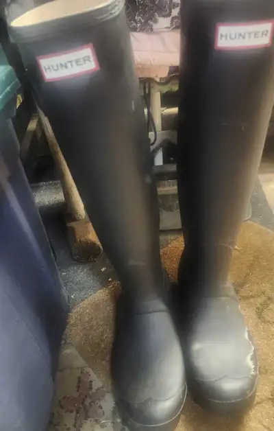 These are a pair of used Women's Hunter black rain boots, perfect for keeping your feet dry in style...