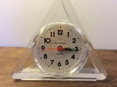This quartz desk clock by Rene Valentin, France, features a unique triangular shape with an open sty...