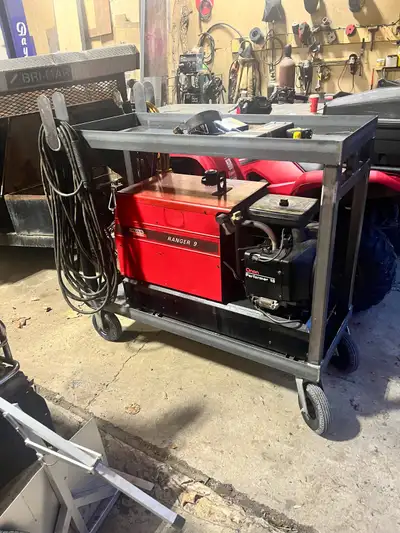Costume welding cart on wheels. Has bull horns for cable storage, the top is also a tool tray and ha...