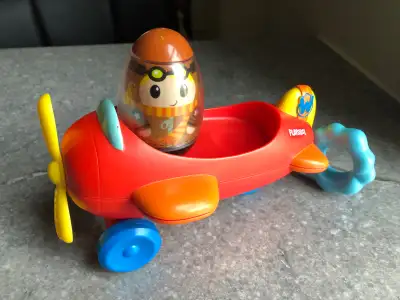 By Hasbro, 2010. Pull the blue ring on the back and airplane shakes , making the pilot (or other wee...