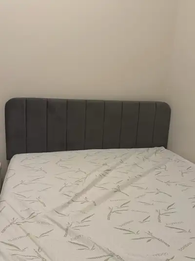 Queen-size grey upholstered bed frame with matching headboard and mattress included. Clean, modern l...