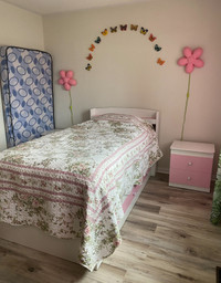 Two twin beds with teo matching night stands white and pink 