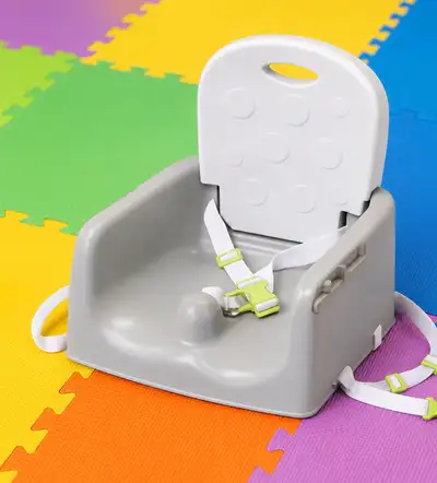 Portable toddler booster seat that securely straps onto a regular dining chair, allowing your child...