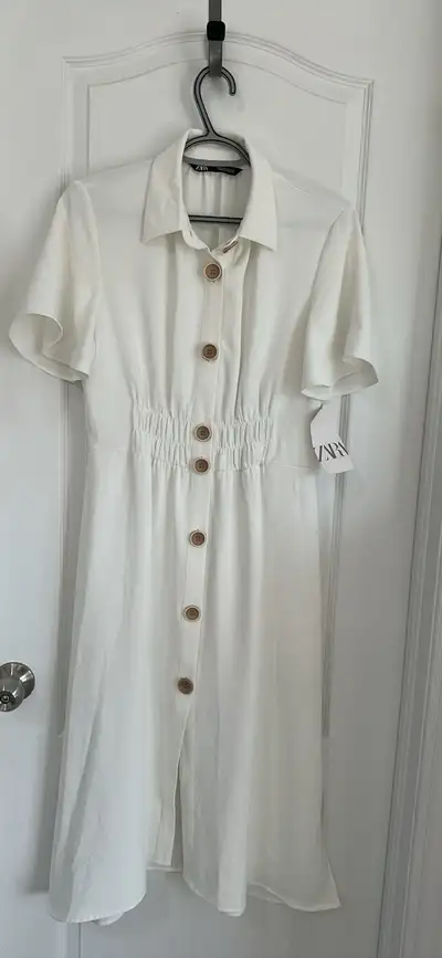 This is a Zara dress, a button-down midi with a collared neckline and short sleeves, still new with...