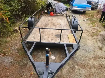 This is a utility trailer in used condition, ready for hauling. The trailer features a sturdy frame,...