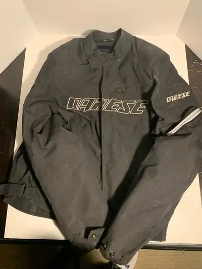 This is a black Dainese motorcycle jacket, size 48. It's in used condition, perfect for someone look...