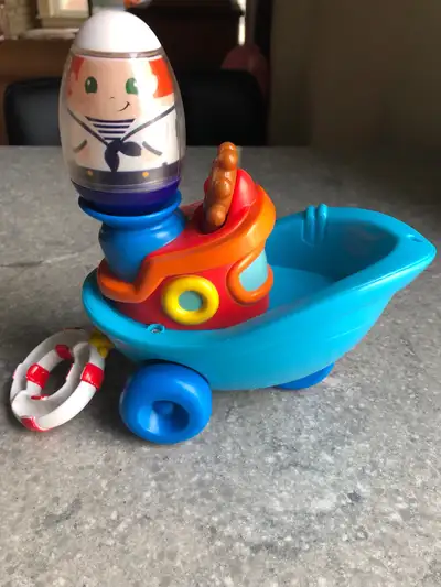 By Hasbro, 2010. Pull the blue ring on the back and boat shakes , making the sailor (or other weeble...