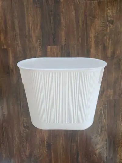 White plastic garbage can. Measures 1 foot across by 7 inches and 10 inches deep.