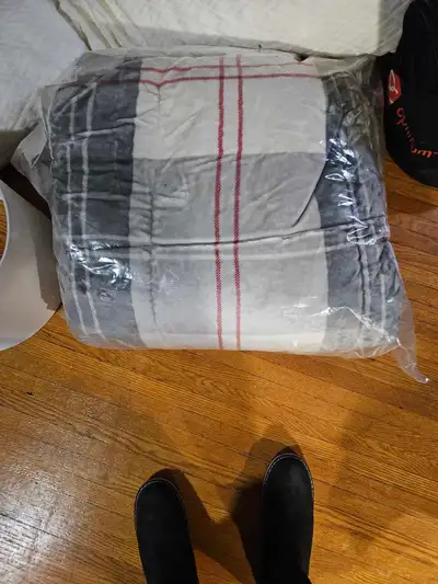 This is a cozy, grey and white plaid plush blanket, with red accents. It's in excellent condition, r...