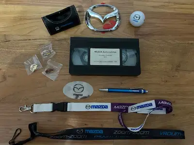 LOT D OBJETS PUBLICITAIRES MAZDA MX5 MIATA DEPUIS 1995 - PORTE CLES - INSIGNES ORIGINAUX K7 VIDEO DE...