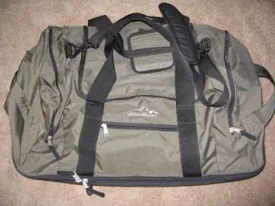 Eddie Bauer Green rolling duffle bag Features multiple pockets and compartments Durable construction...
