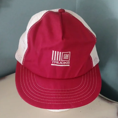 This red canvas cap features GM TRUCKS embroidered in white on the front and white mesh on the sides...