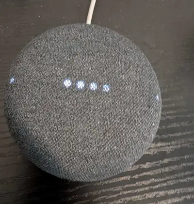 This pre-owned Google Nest Mini smart speaker features a compact, charcoal fabric design and provide...