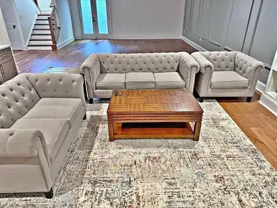 This used living room set features a stylish chesterfield design, including a sofa, loveseat, chair,...