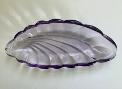 This vintage glass leaf shaped dish features delicate scalloped edges and a lovely purple hue. It me...