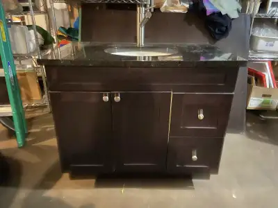 This is a used 36-inch solid wood vanity with a granite top, offering a stylish and functional addit...