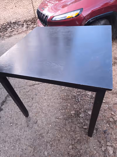 This square, dark-stained table and four matching chairs are perfect for a small dining area or brea...
