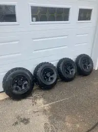 Four 25 inch Carlisle tires on Polaris rims