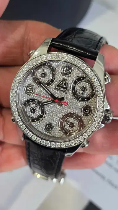 This unisex 40mm Jacob & Co watch features a factory set natural diamond-encrusted pave dial and dia...