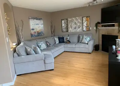This grey sectional couch is in great condition and features a pull-out sleeper mechanism with built...