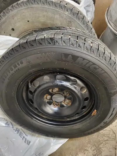 Selling a set of four used Michelin winter tires mounted on steel rims, complete with tire pressure...